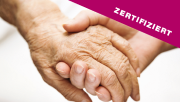 Zwei Hände halten sich fest, eine Hand von einer/einem Senior*in, die anderen von einer jüngeren Person – im Blickfang steht "zertifiziert"