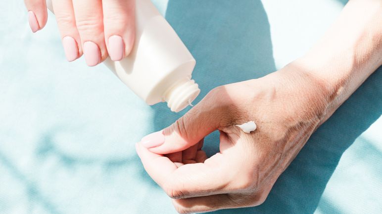 Eine ältere Dame benutzt eine feuchtigkeitsspendende Handcreme