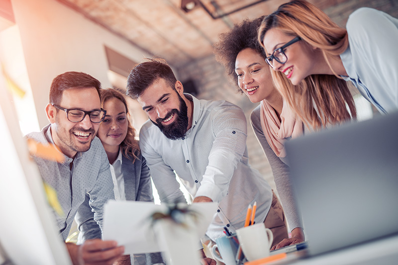 Team, das gemeinsam am Laptop arbeitet
